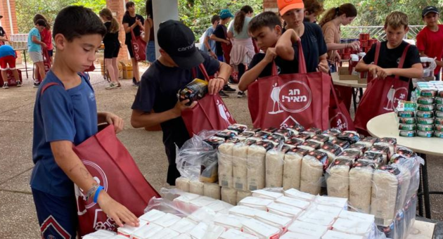 מתנדבים מהקיבוצים אורזים סלי מזון לנזקקים